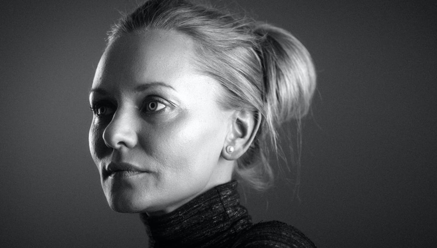Woman with hair up looking to the side with a serious facial expression