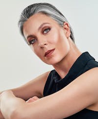 Middle aged woman with full face of makeup and serious facial expression