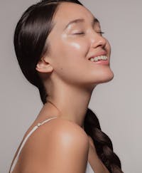 Beautiful woman with dewey skin closing her eyes