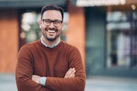 Man smiling wearing a burnt orange sweater