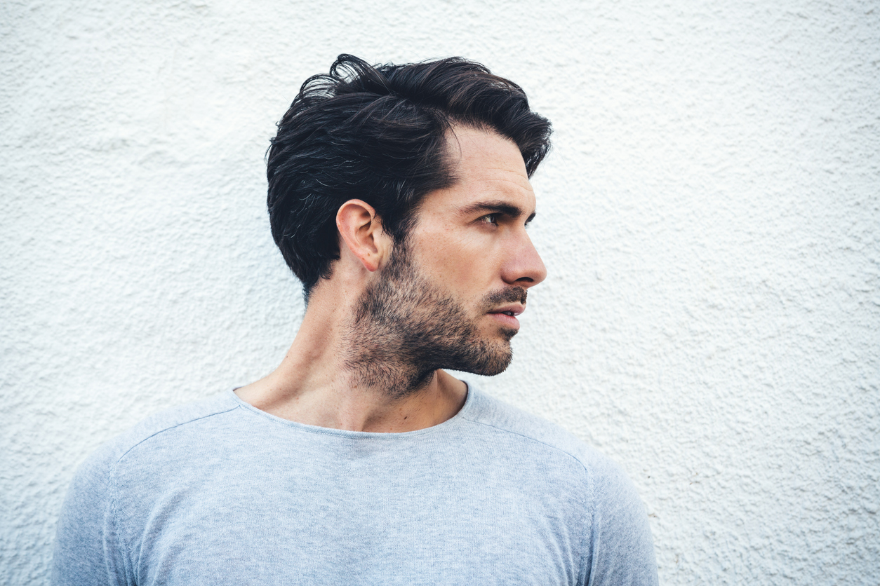 A man with dark hair looking to side