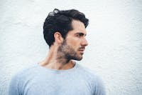 A man with dark hair looking to side