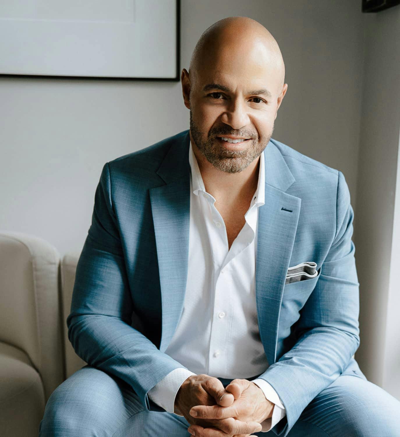 Dr. Pratt sitting in a blue suit smiling