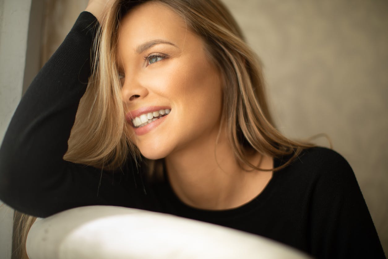 Woman in a black blouse leaning her head on her hand
