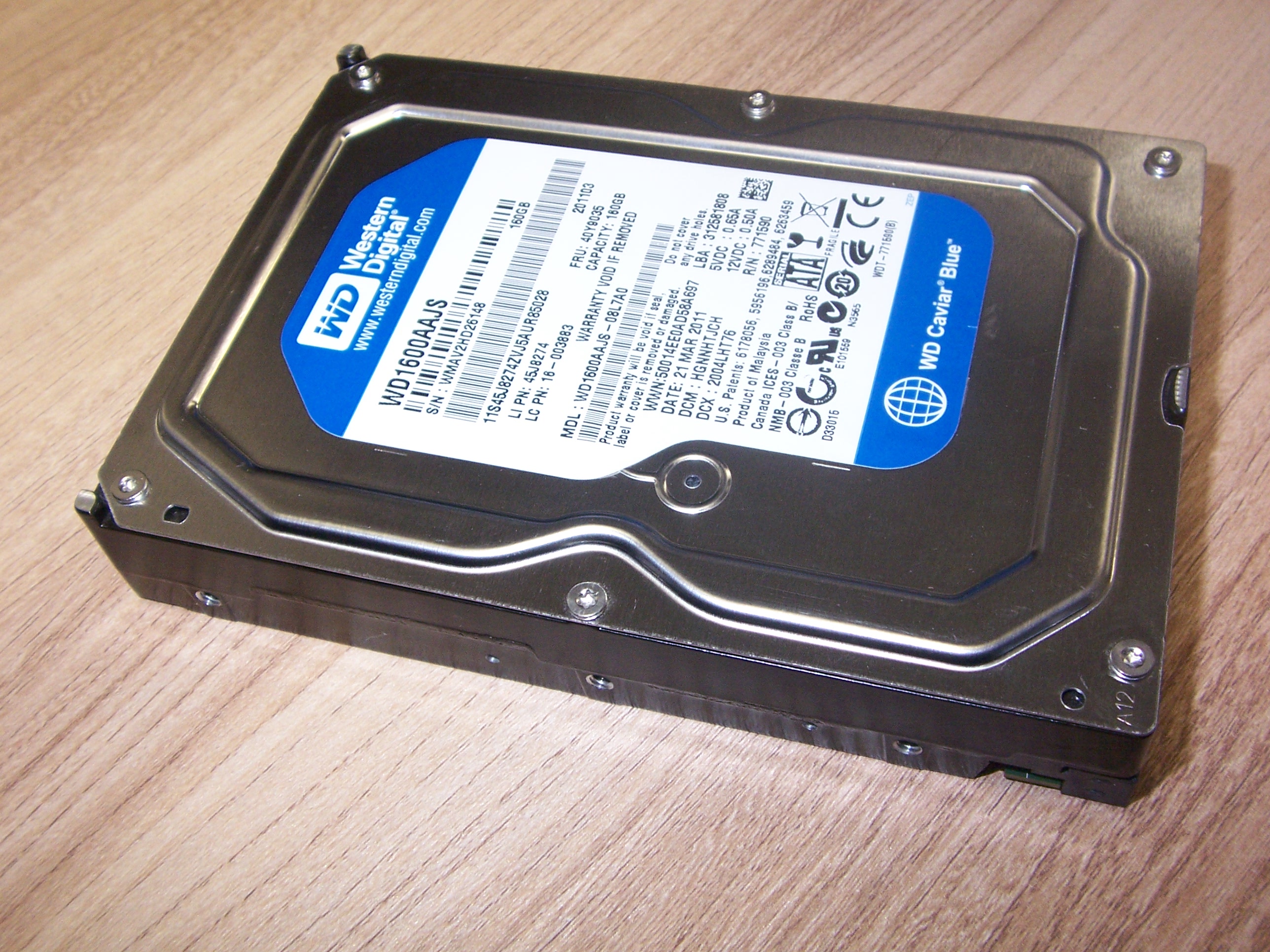 Dysk 3,5 cala Western Digital z niebieskimi elementami etykiety, na drewnianym blacie