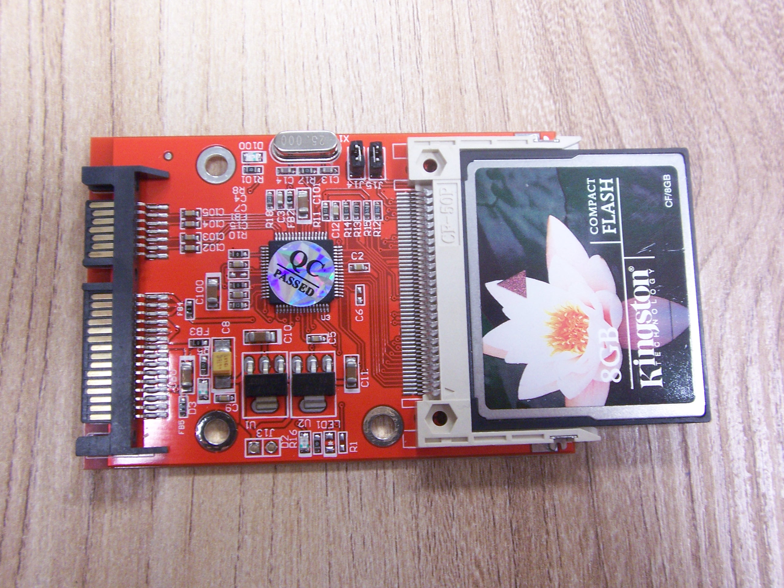 Przejściówka SATA - CompactFlash, widoczne złącze SATA i slot CF z zainstalowaną kartą.