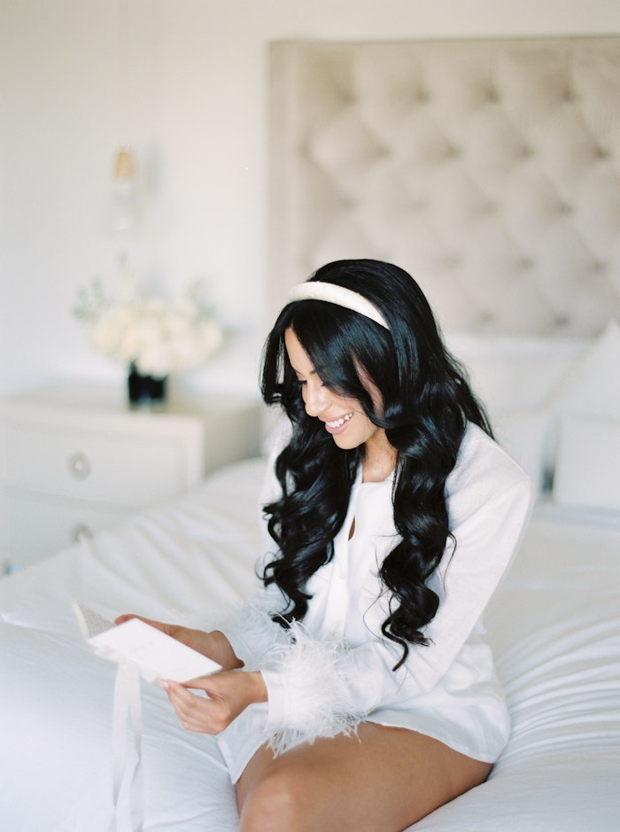 Wedding Photograph of a bride in Toronto opening a card and smiling.