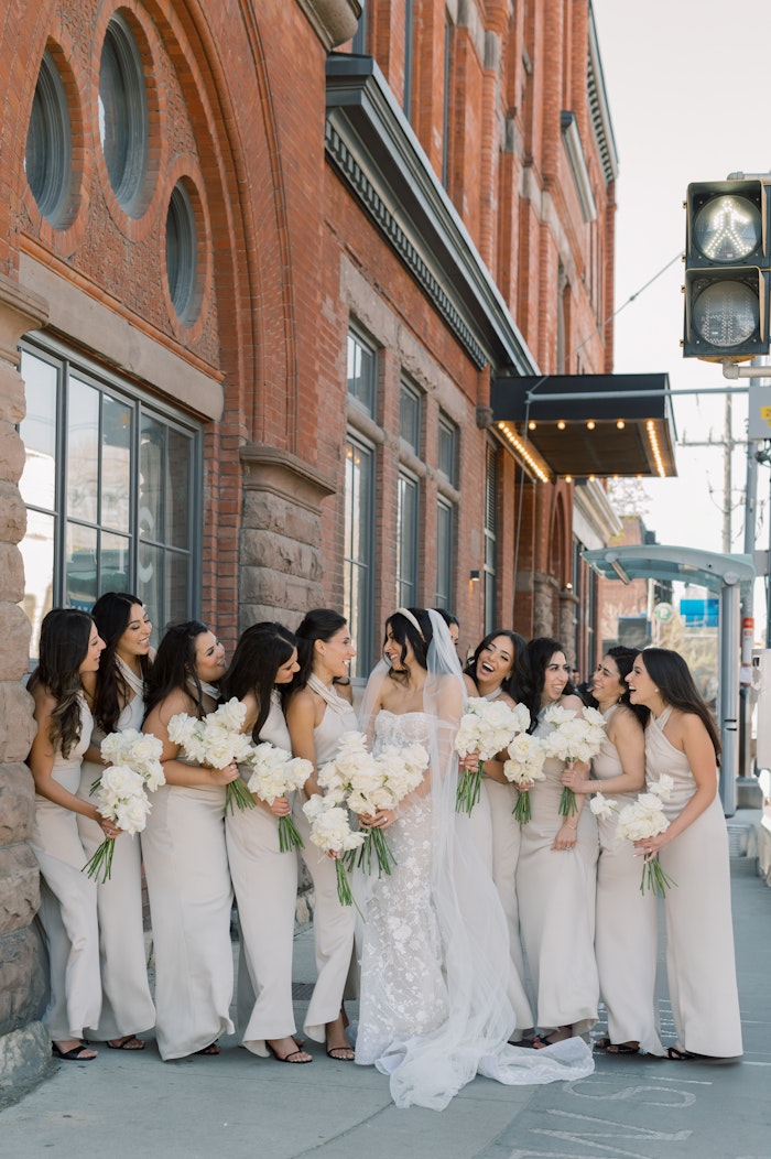 Bride and Bridesmaids laughing and taking photos outside the Broadview Hotel in Toronto