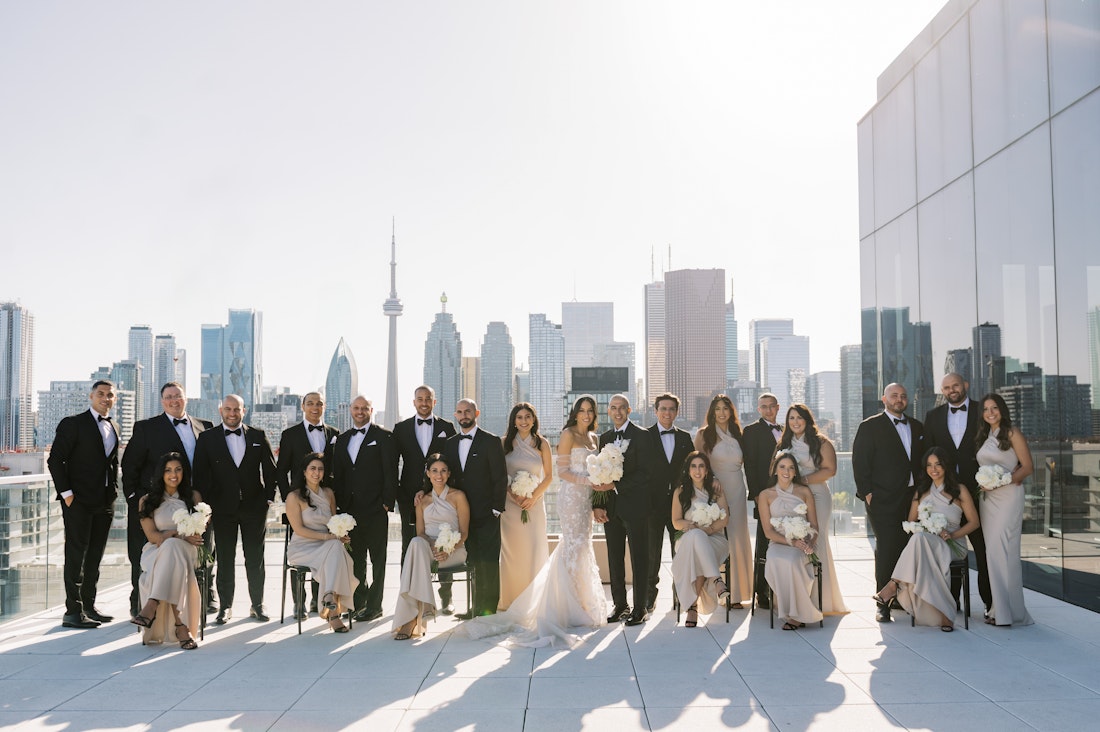A large wedding taking photos with the Toronto skyline in the back at the Globe and Mail