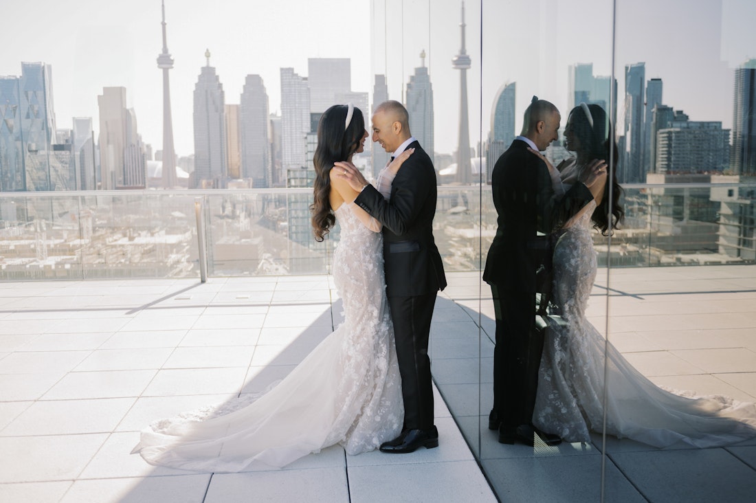 Modern urban wedding couple portrait Toronto skyline showcasing reflections in a creative way.
