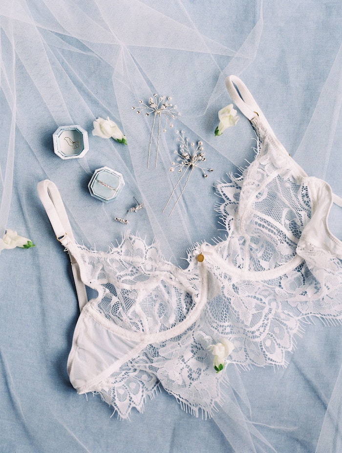Toronto wedding photographer capturing soft blue wedding stationery flat lay with hair pins and bra at Spadina House Museum