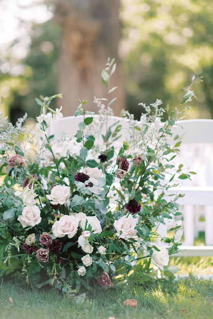 Flowers ar Outdoor wedding ceremony at Spadina House Museum Toronto with guests seated in garden setting