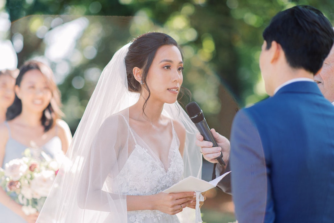 Bride and groom exchanging vows during garden wedding ceremony at Spadina House Toronto