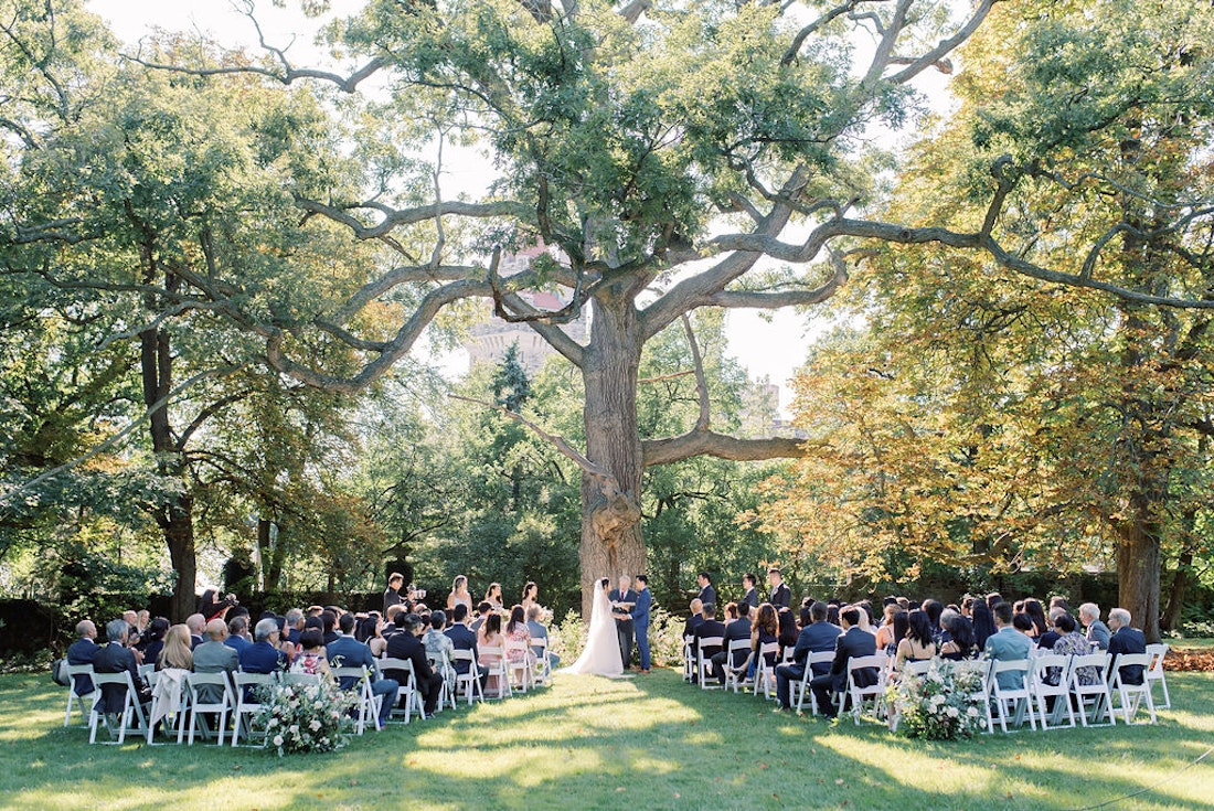 Outdoor wedding ceremony at Spadina House Museum Toronto with guests seated in garden setting