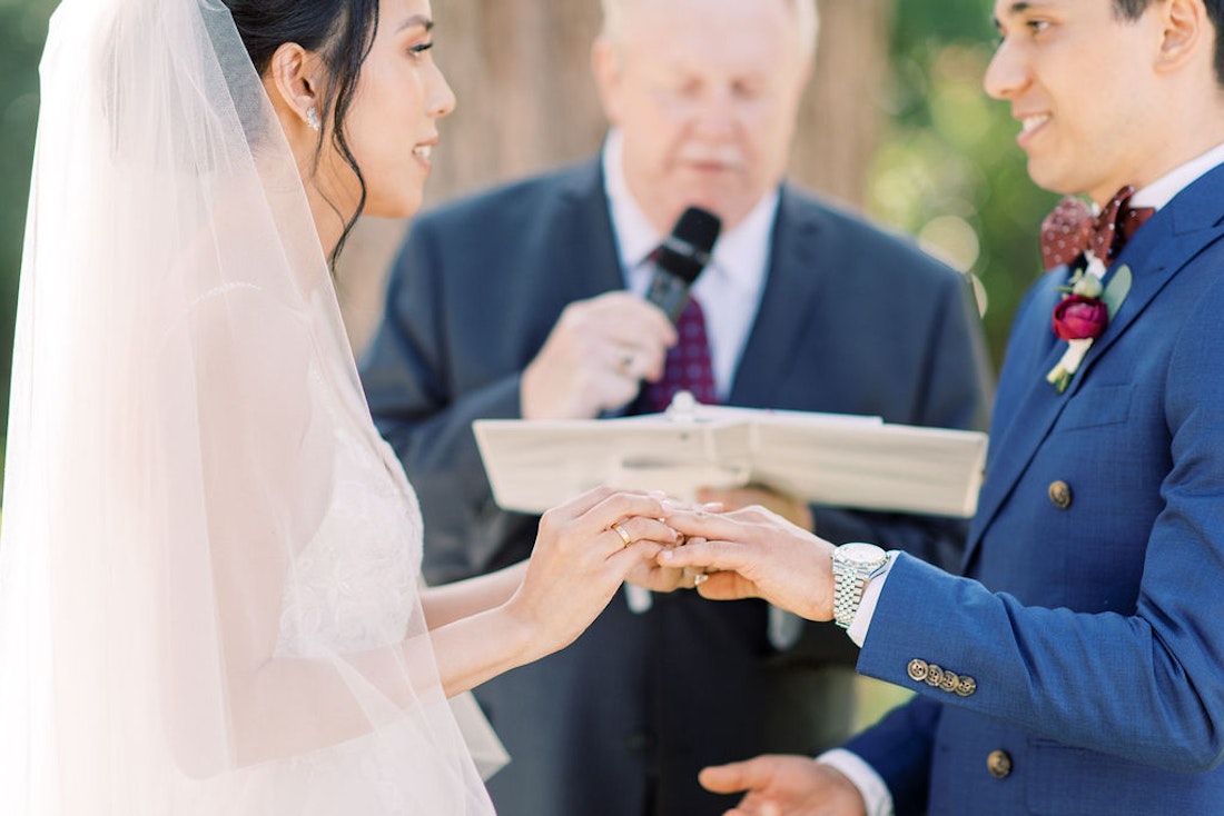 Bride and groom exchanging vows during garden wedding ceremony at Spadina House Toronto