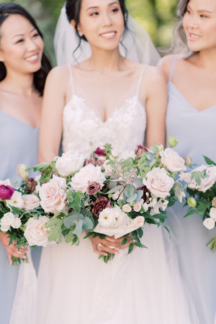 Bride and bridesmaids with bouquets in garden at Spadina House Toronto wedding