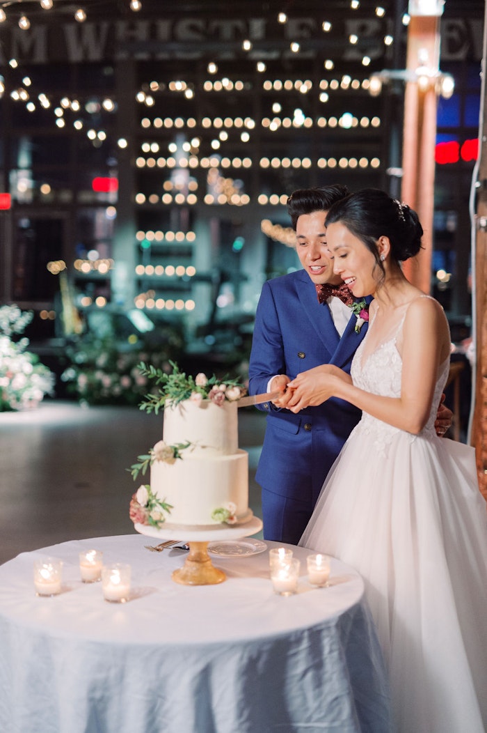 Bride and Groom cutting their cake at Wedding reception catering by Food Dudes at Steam Whistle Roundhouse Toronto wedding