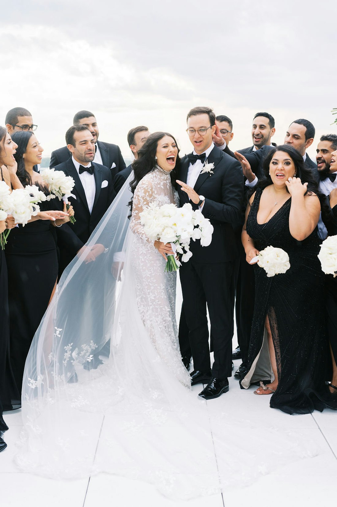 Bride and groom surrounded by friends during joyful group moment