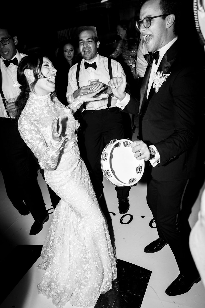 Bride and groom dancing with tambourines lively reception