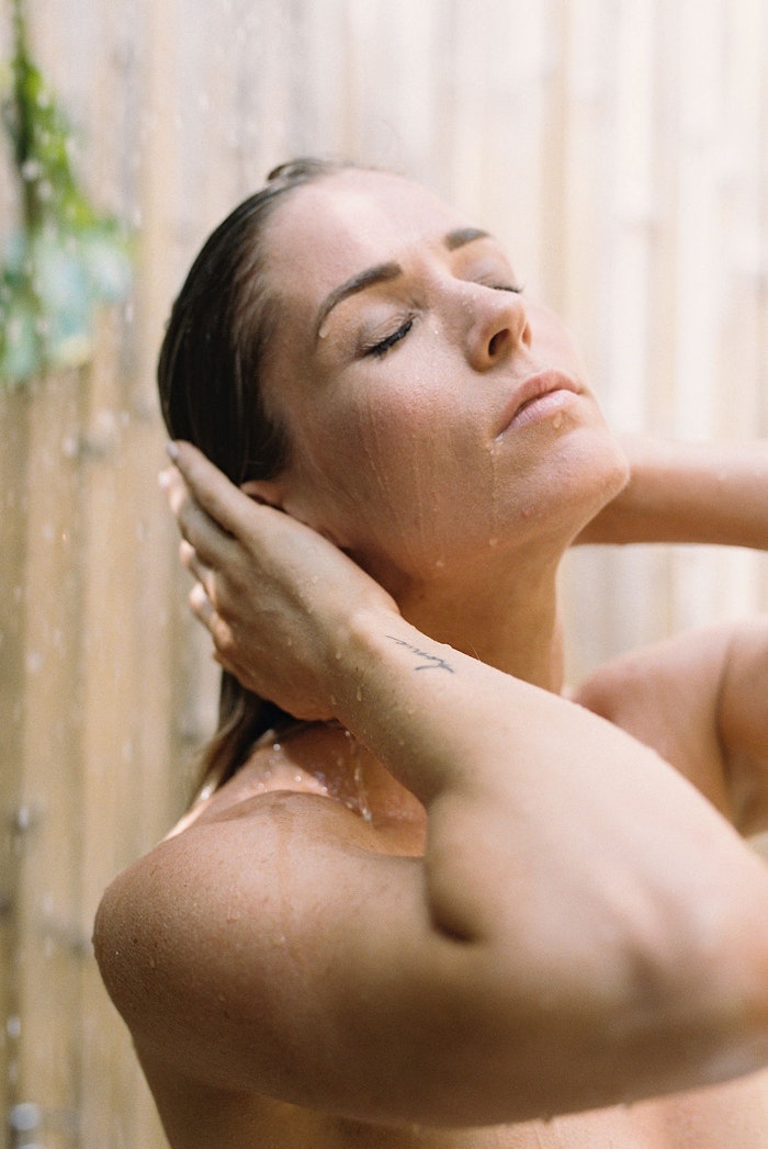 Bride standing under water in Bali, photographed in a soft and intimate editorial style with natural light