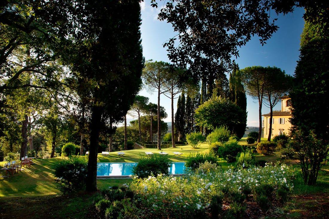 A swimming pool in the shade of trees The heated swimming pool in Villa La Tavernaccia is surrounded by a private garden