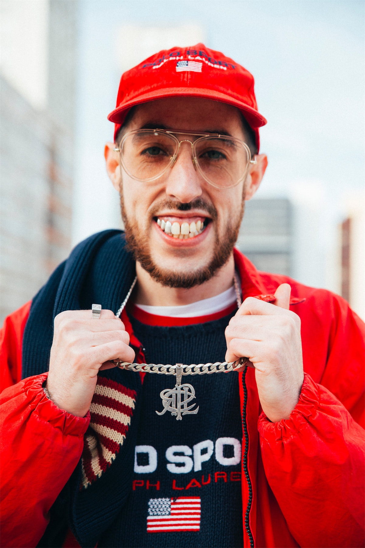 Portrait of a smiling man wearing Polo Sport sweater and a red jacket and cap.
