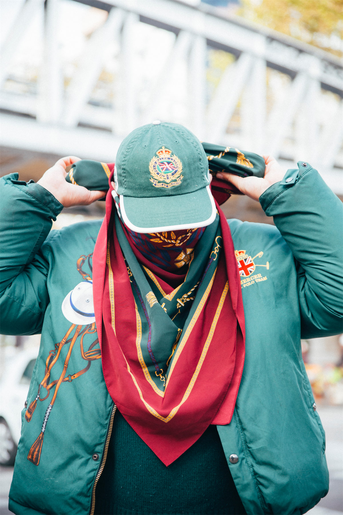 A portrait of a man wearing a green jacket and a cap.