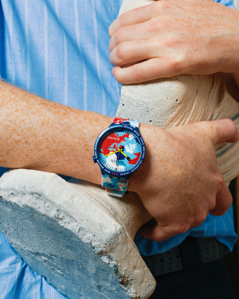 Close up of an arm wearing a swatch x bape watch.