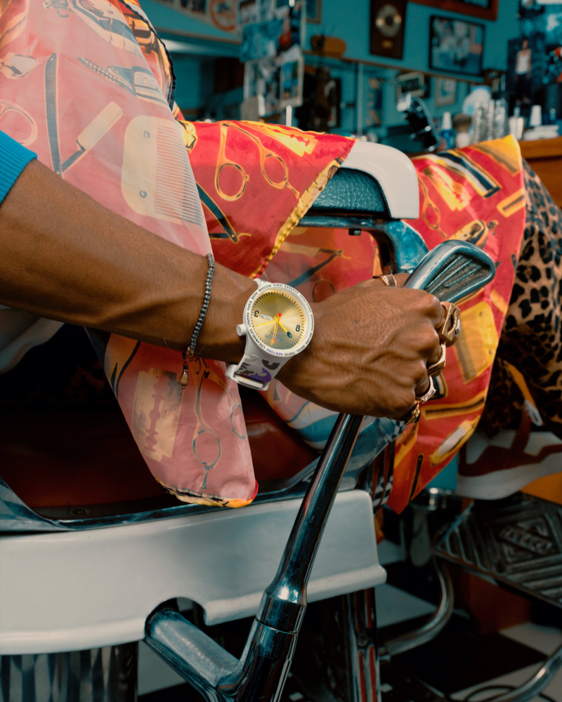 Close up of an arm wearing a swatch x bape watch.