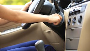 woman with hand on ignition starting manual transmission car