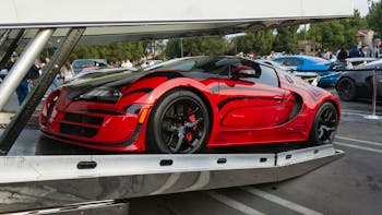 Red Bugatti Veyron entering enclosed auto transport