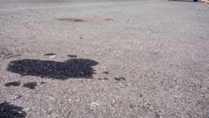 Oil leakage from old car on the Street