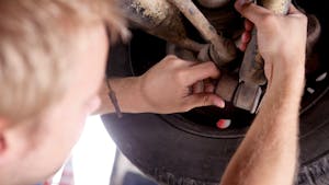 Mechanic Inspecting Shock Absorber