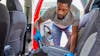 Man Hoovering And Cleaning Rear Seats Of Car