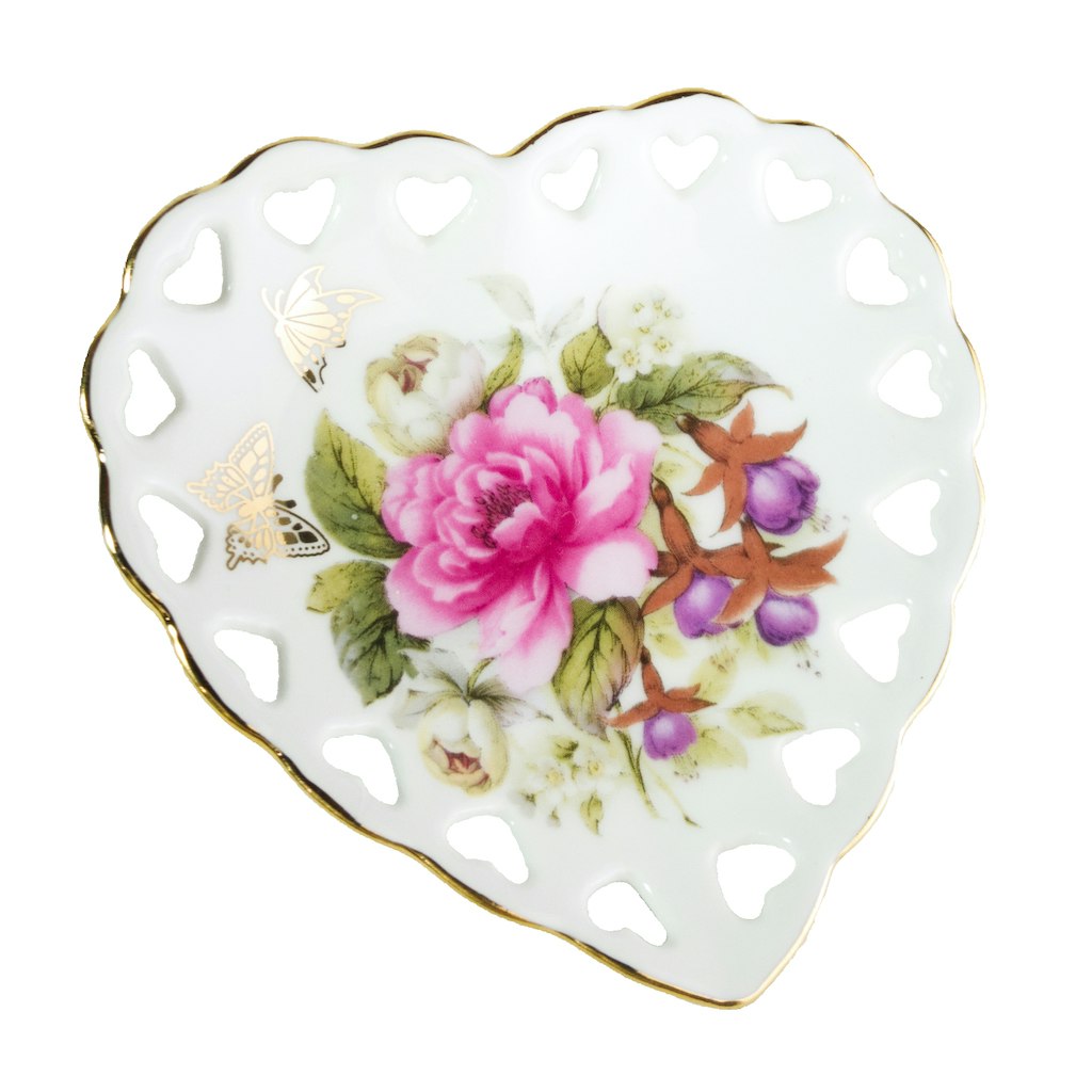 Peça de porcelana em formato de coração com flores e borboletas.
