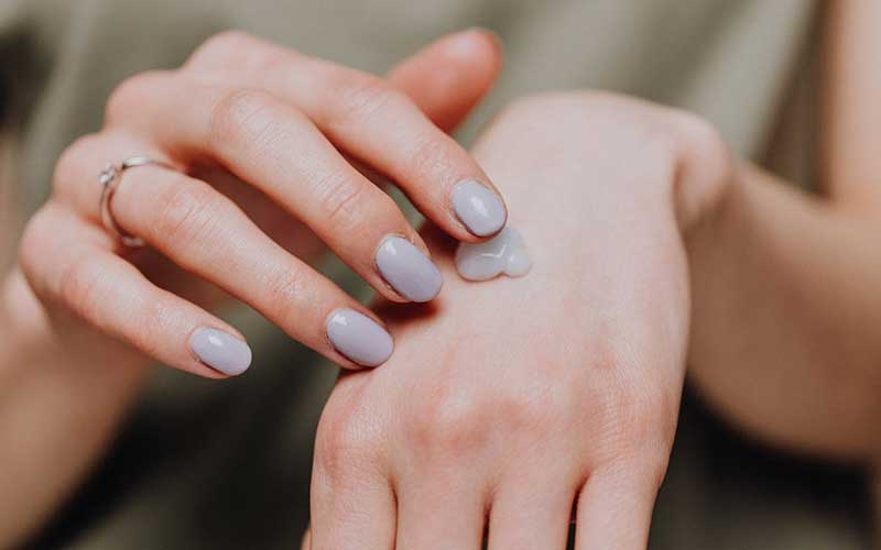woman applying cream on her hand