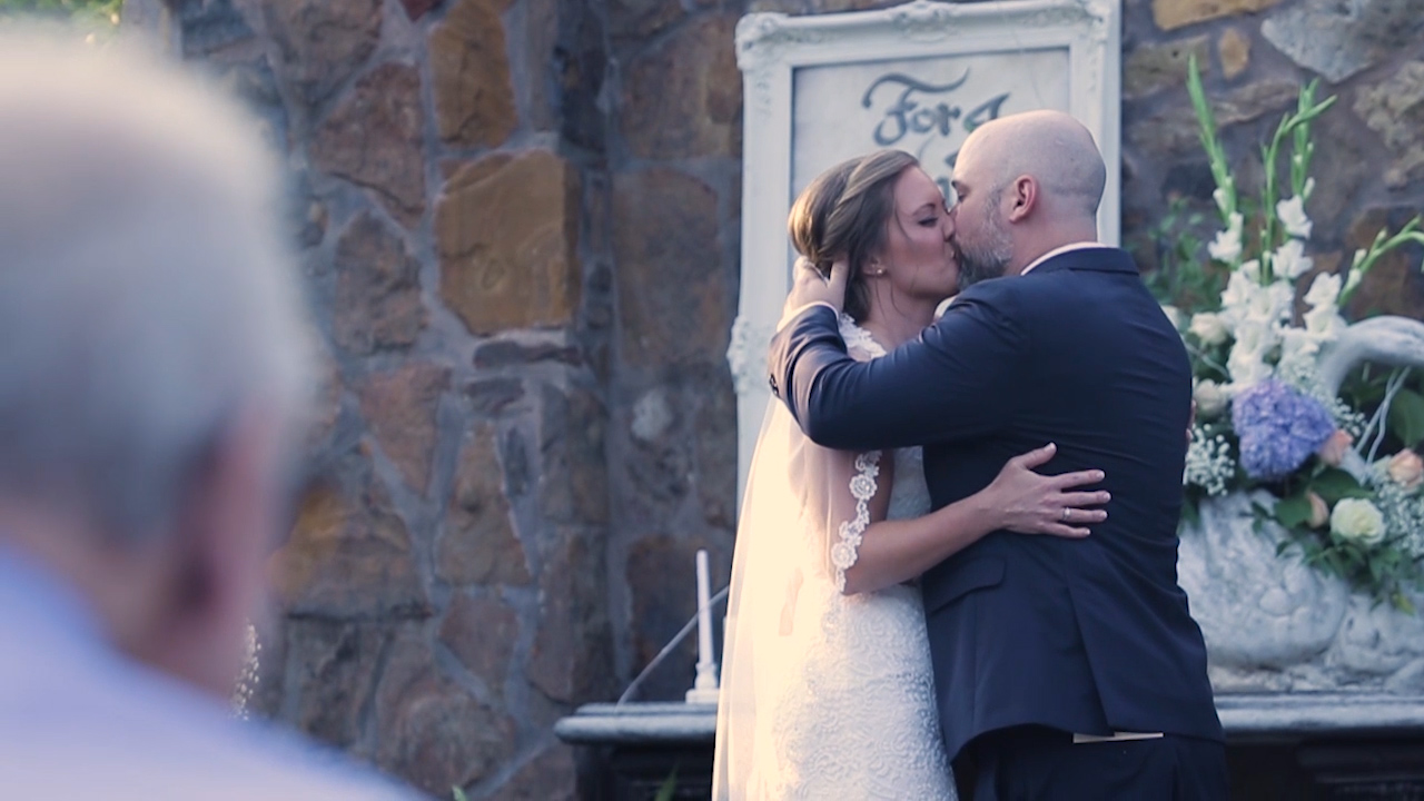 Nicole and Henry share a kiss during their wedding ceremony