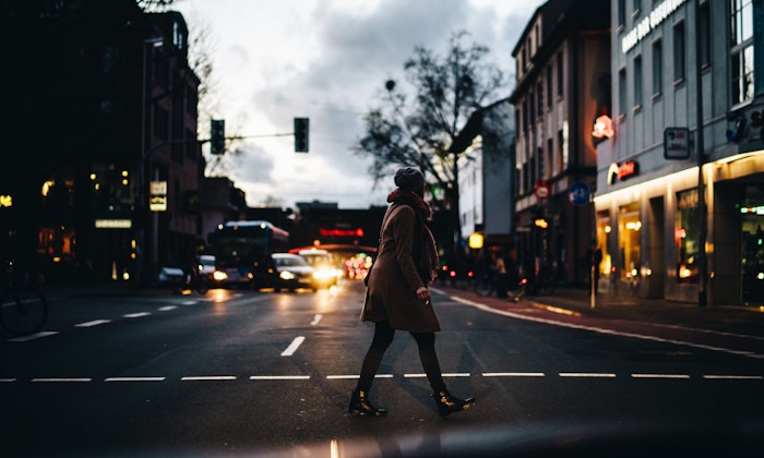 Woman walking on street with cars