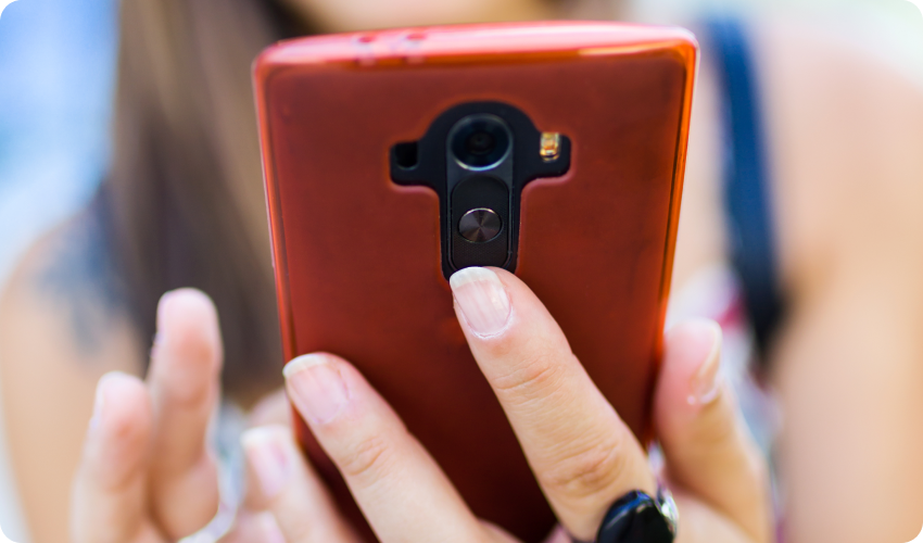 Woman holding her Android smartphone during the warm weather