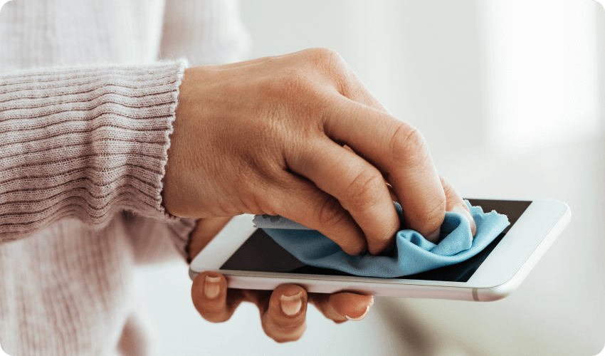 a woman cleaning a phone with a microfiber cloth