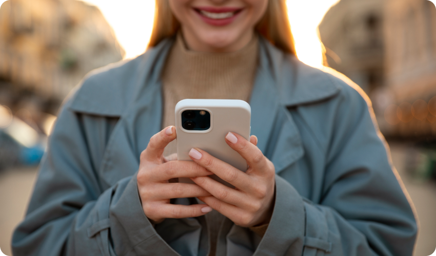 Smiling woman holding an iPhone in both hands