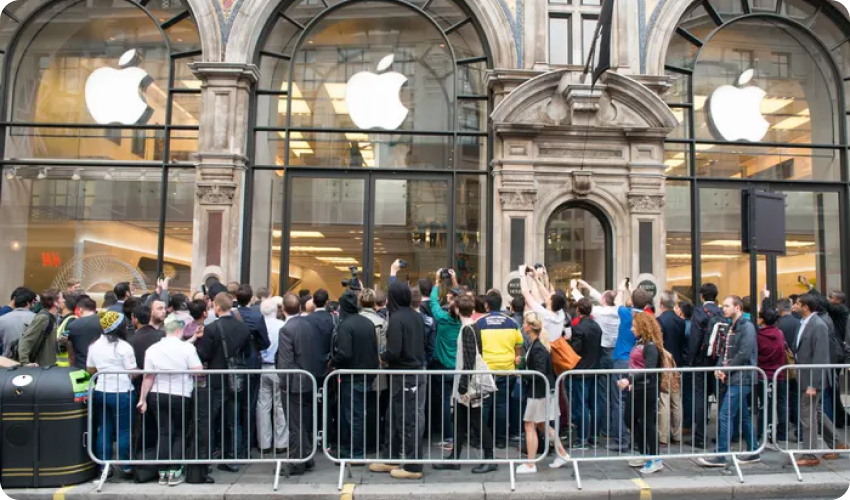 Customers queueing in a large crowd outside an Apple store