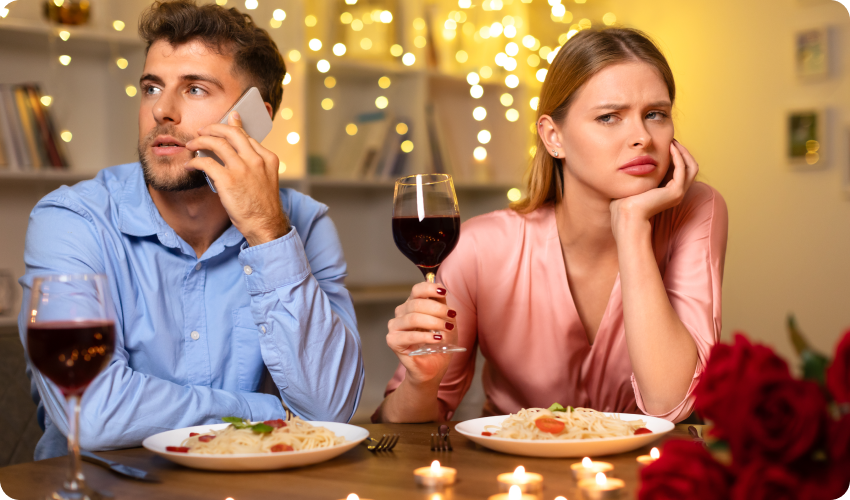 Man on the phone ignoring woman whilst on a date