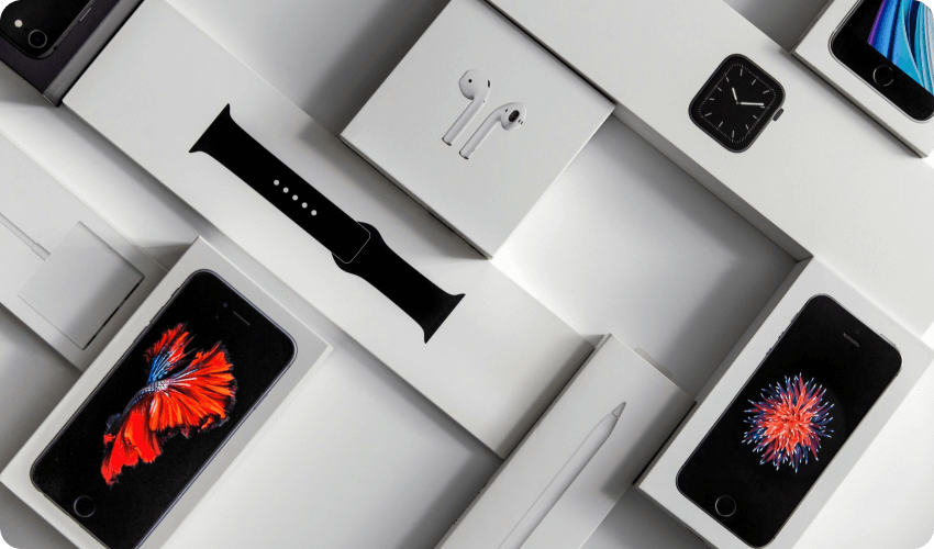 brand new gadgets in retail boxes laying on a flat white surface