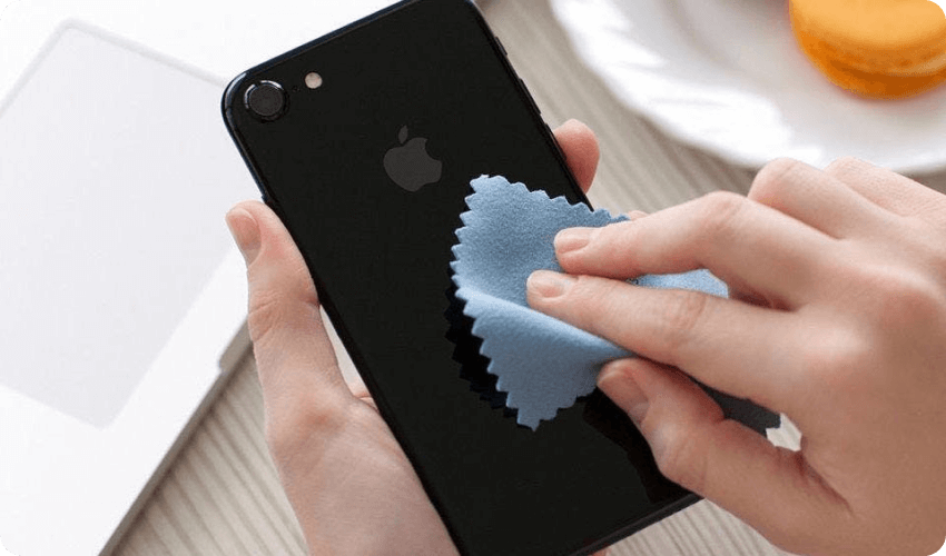 Person cleaning an iPhone