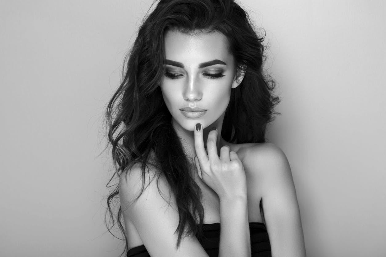 black and white image of woman touching her chin