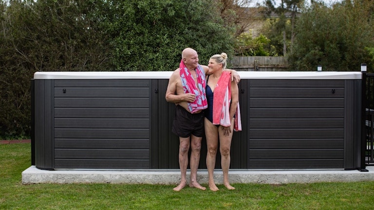 Swim spa on a concrete pad in backyard