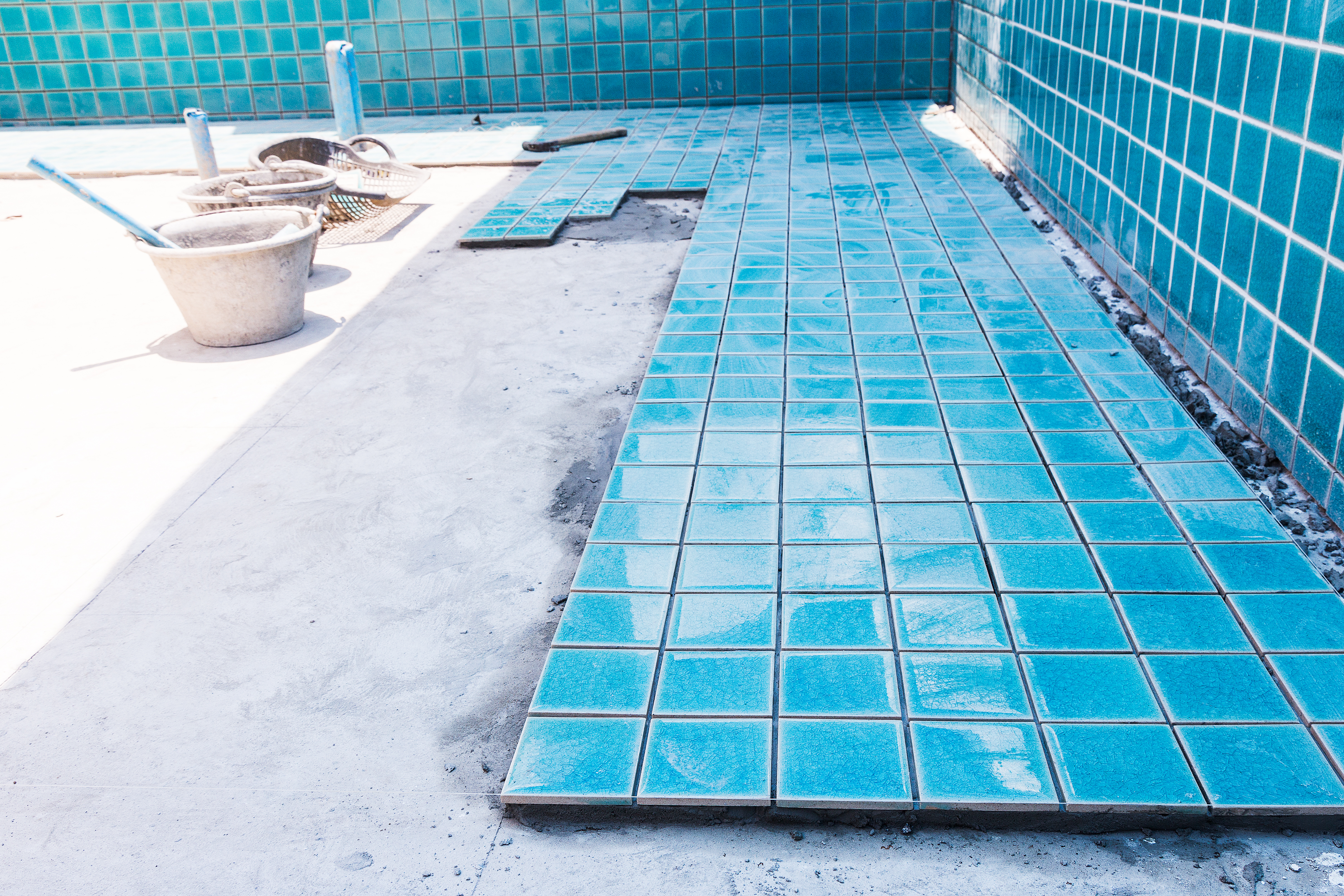 Installing ceramic tiles on a concrete swimming pool
