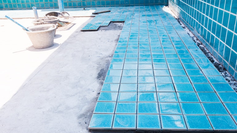 Installing ceramic tiles on a concrete swimming pool