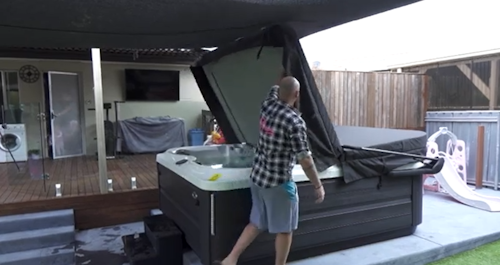 Man lifting a Jacuzzi spa cover